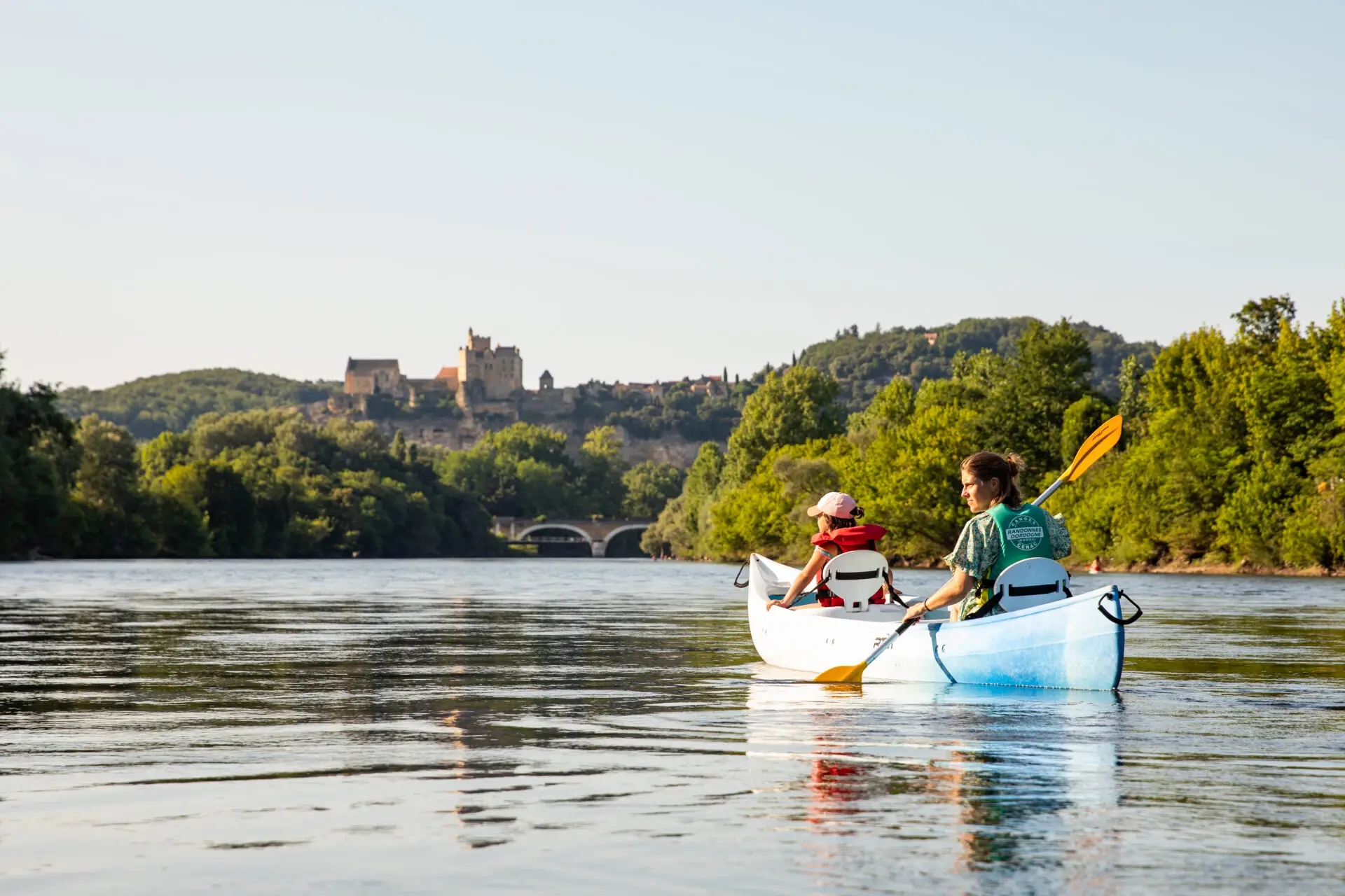 Femme avec sa fille en canoë sur la Dordogne devant Castelnaud-la-Chapelle