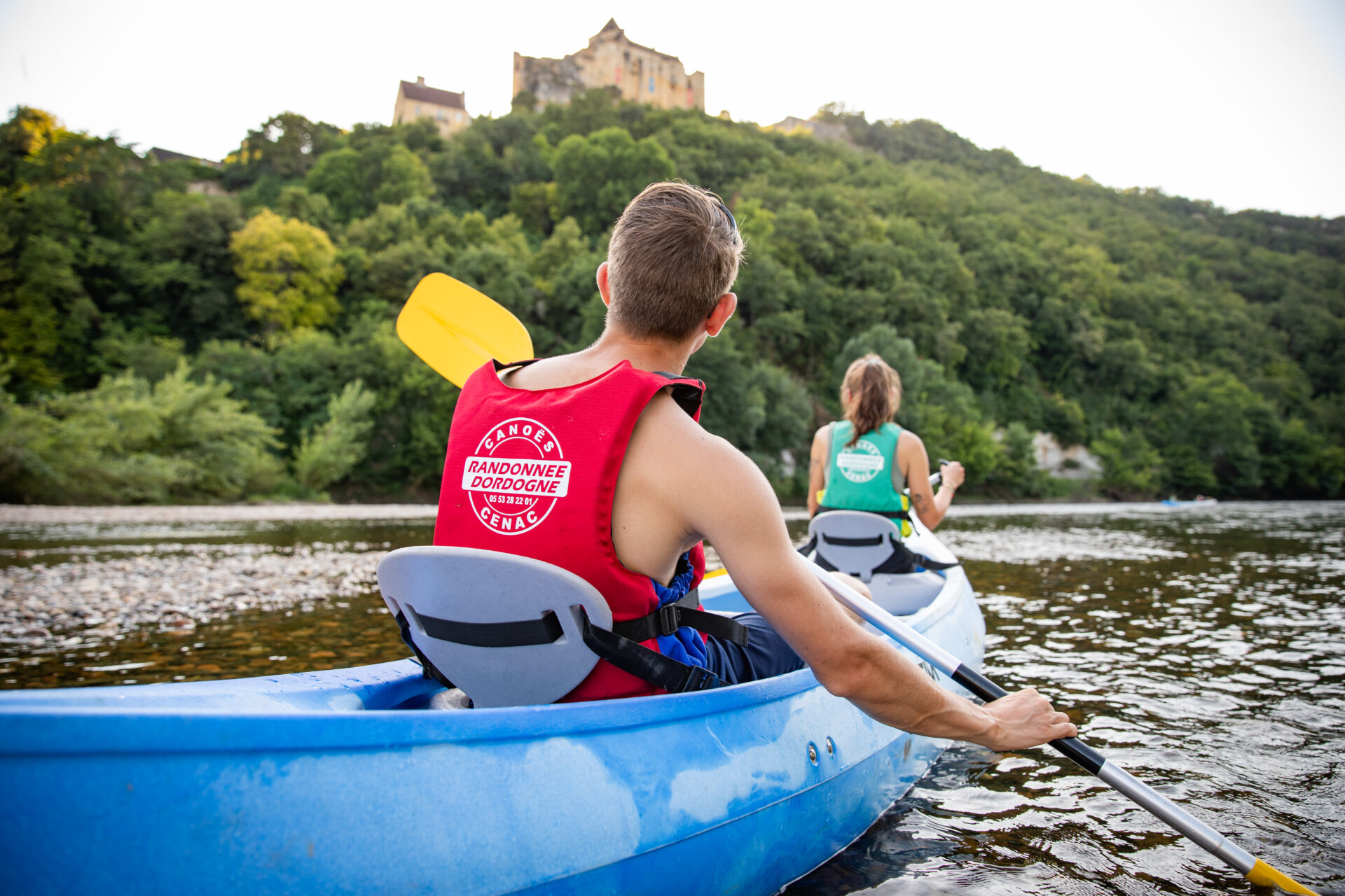 Couple en canoë observant le château de Castelnaud-la-Chapelle
